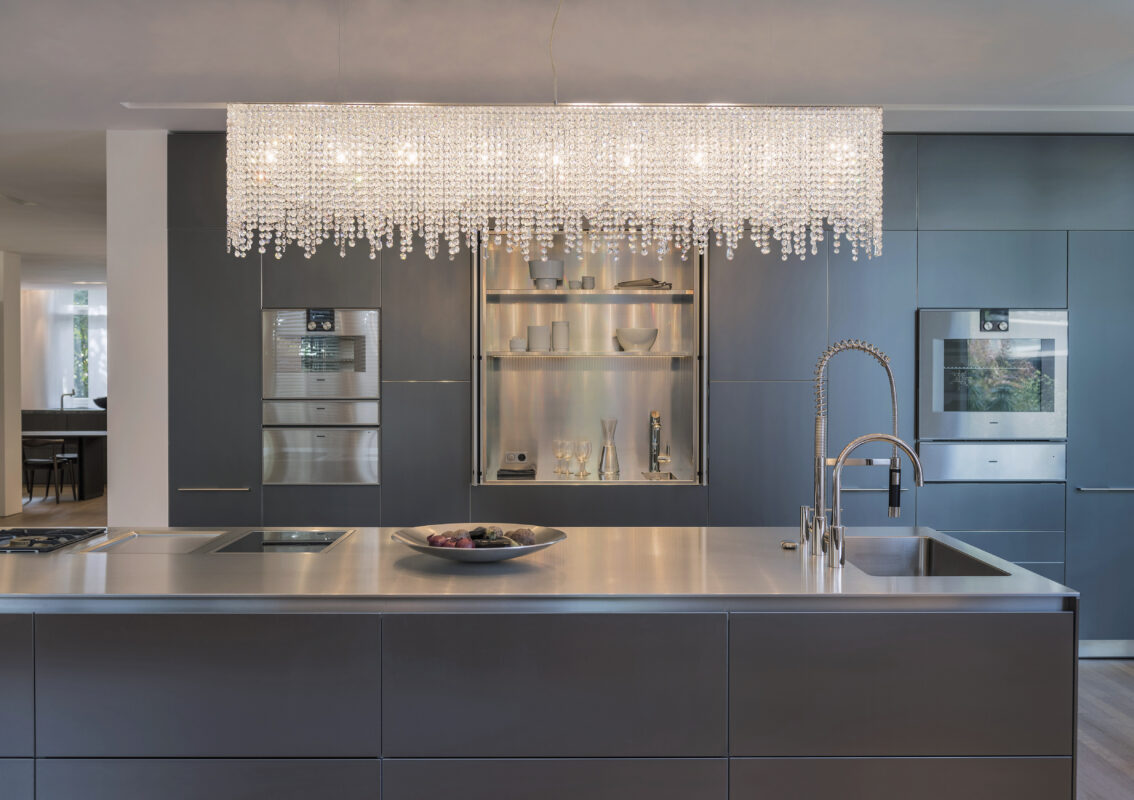 Linea luxury crystal chandelier by Manooi above a modern kitchen island
